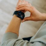 Close up of a woman's arm who is touching her smartwatch.