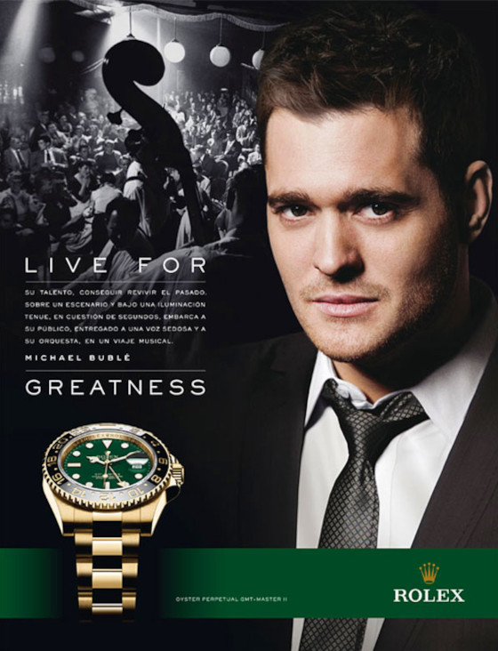 Ad cartaceo per Rolex in spagnolo. In primo piano a destra c'è il viso del cantante Michael Bublé, a sinistra l'orologio e il claim "Live for greatness".